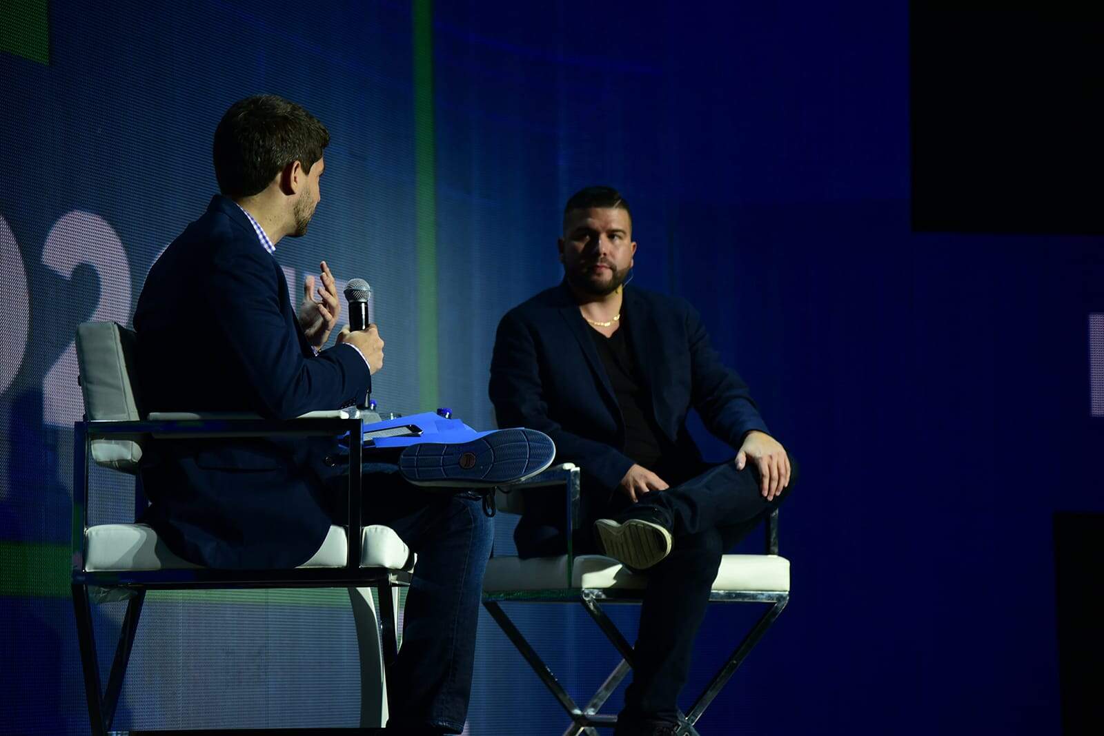 Niv on stage speaking at a live coaching event