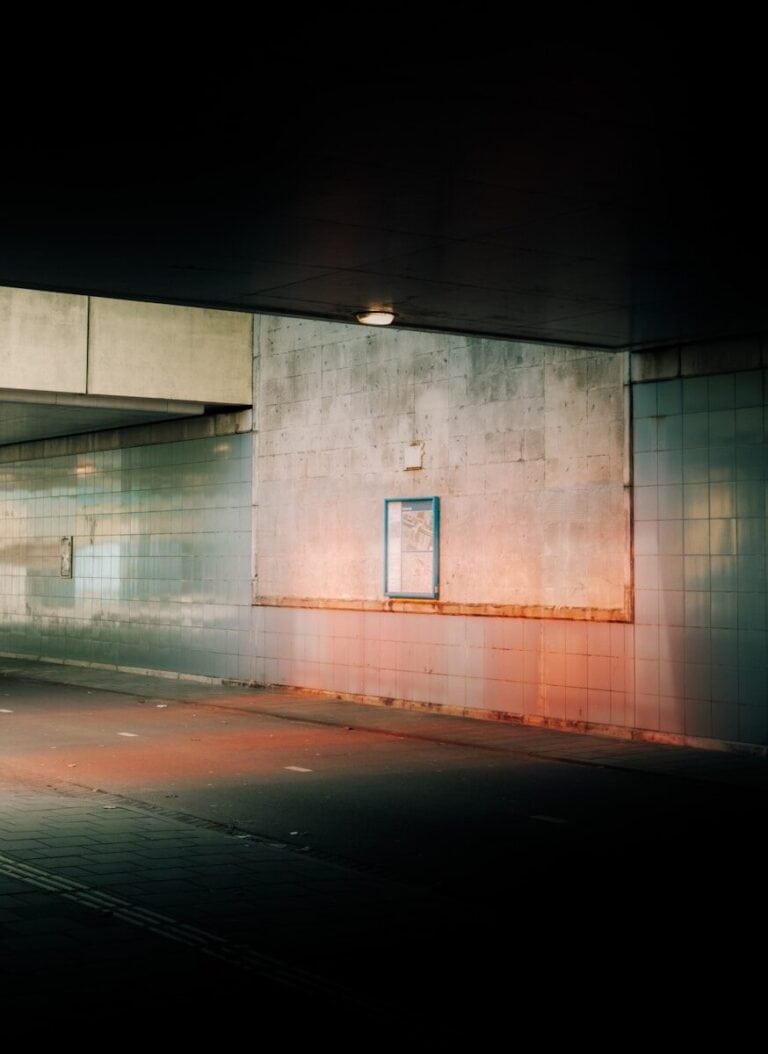 Dark underpass with a small illuminated sign, symbolizing persistence in the job search in Germany — Niv Nicolas Nowbakht Business Coach Berlin